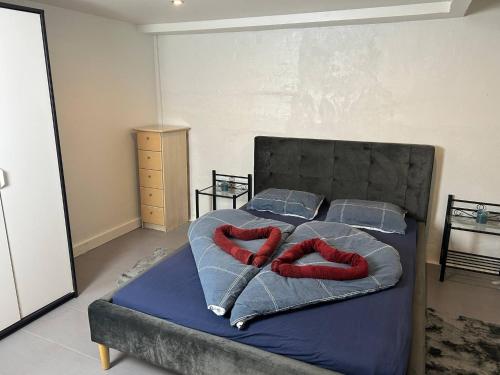 a bedroom with a bed with red blankets and pillows at Basement Apartment in Villa in Odense