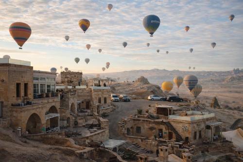 a bunch of hot air balloons flying in the sky at Azure Cave Suites - Cappadocia in Göreme