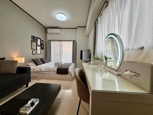 a living room with a bed and a mirror at Lion Heiwa Odori in Hiroshima