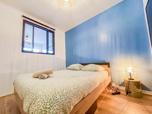 a bedroom with a bed with a blue wall at Bel appartement à Royat in Royat