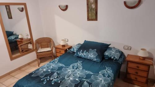 a bedroom with a bed with blue sheets and a mirror at Medano House Ocean Beach in El Médano