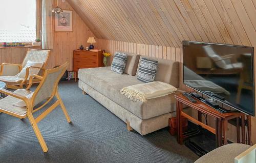 a living room with a couch and a flat screen tv at Two-Bedroom Holiday Home In Rudkobing in Spodsbjerg
