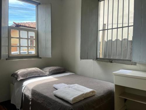 a bedroom with a bed with two towels on it at Casa 89 in Diamantina