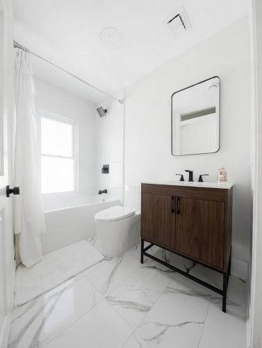 a bathroom with a sink and a toilet and a mirror at Trendy Home Spacious Backyard Historic Walkerville in Windsor