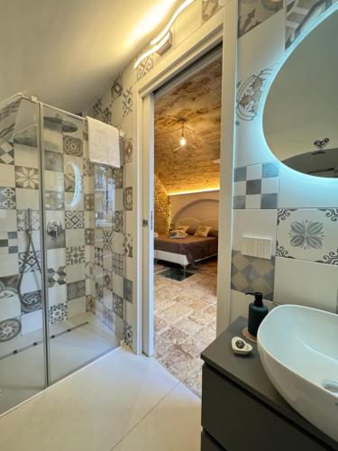 a bathroom with a sink and a mirror and a shower at La Neviera Apulia Rooms in Altamura