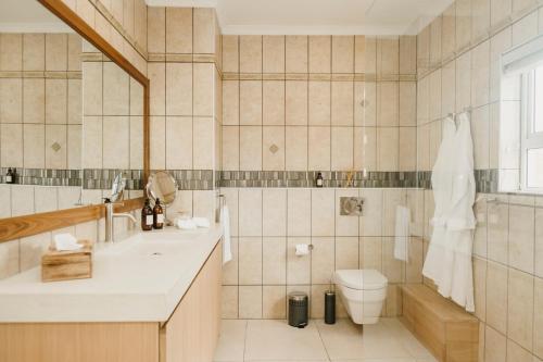 a bathroom with a sink and a toilet and a tub at House Olive in De Kelders