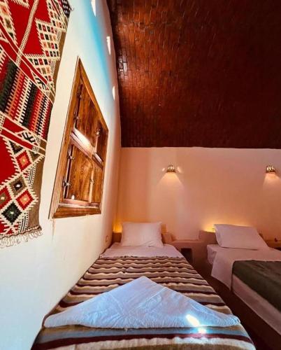 a room with two beds and a window at Aghurmi Siwa Hotel in Siwa