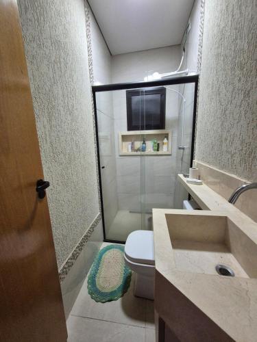 a bathroom with a shower and a toilet and a sink at Casa 4 quartos com piscina em Aparecida de Goiania in Aparecida de Goiânia