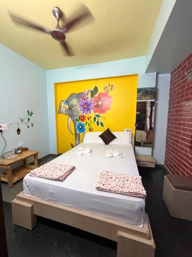 a bedroom with a bed with a painting on the wall at Mango Tree Homestay in Hampi