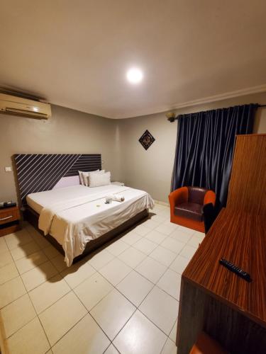 a hotel room with a bed and a chair at Romeo Apartment in Ipaja