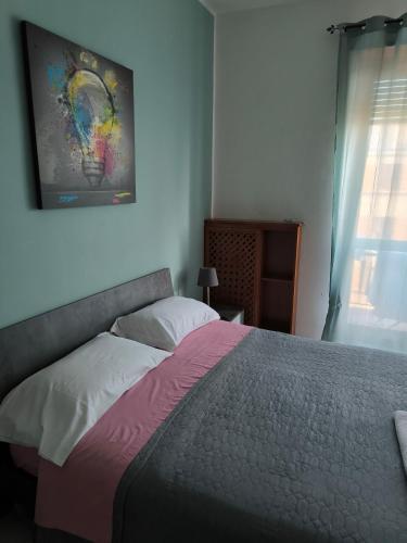 a bedroom with a bed and a painting on the wall at Casa Filadelfia in Turin