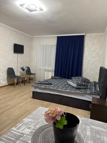 a bedroom with a bed and a blue curtain at Апартамент с джакузи in Khmelnytskyi