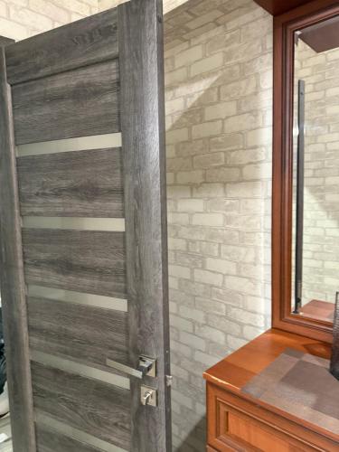 a wooden door in a room with a brick wall at Апартамент с джакузи in Khmelnytskyi