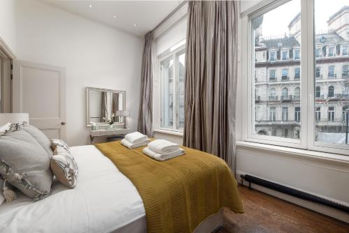 a bedroom with a bed and a large window at Victoria Apartments in London