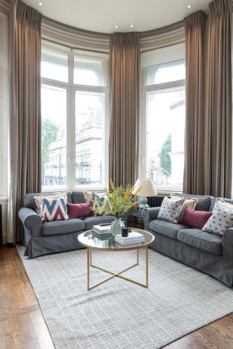 a living room with a couch and a table at Victoria Apartments in London
