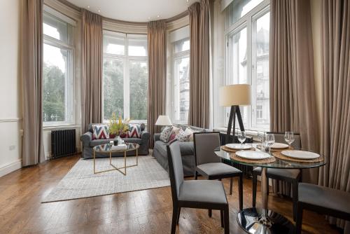 a living room with a couch and a table at Victoria Apartments in London