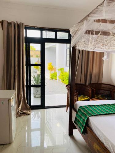 a bedroom with a bed and a sliding glass door at Terrys villa pool view room in Kidoti