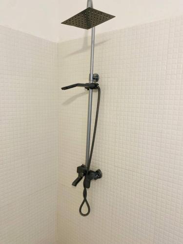 a shower wand in a corner of a bathroom at Terrys villa pool view room in Kidoti