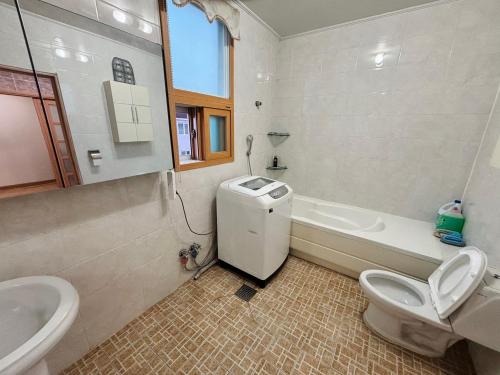 a bathroom with a toilet and a sink and a tub at 파노라마 스테이 in Paranjang