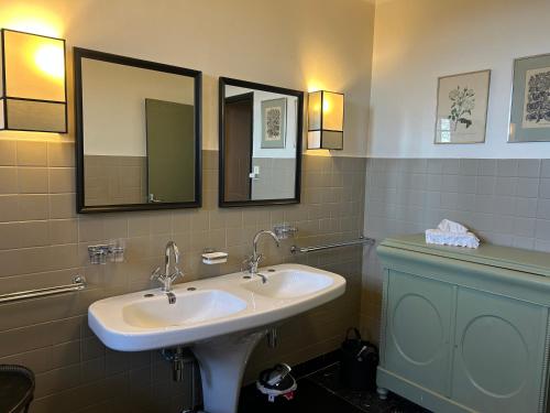 a bathroom with a sink and two mirrors at Maison familiale de charme in Chalabre