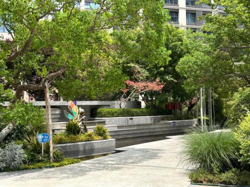 a garden with bushes and trees in a city at 春江屿舍 in Xi'an