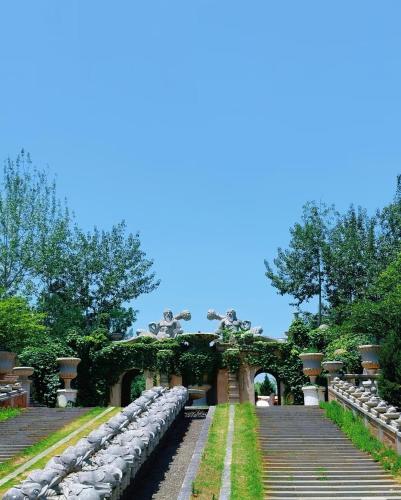 a garden with an arch and stone steps at 春江屿舍 in Xi'an