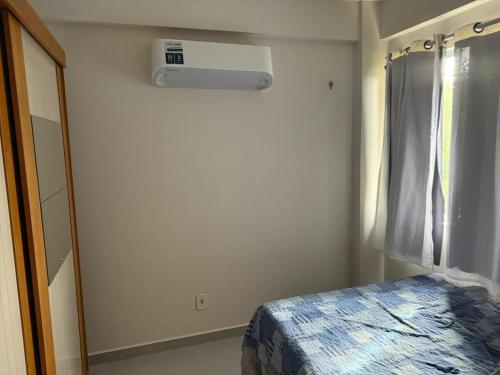 a small bedroom with a bed and a window at Apartamento confortável in Santarém