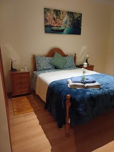 a bedroom with a bed with a blue comforter at Q1 Blueroom Sofia's Happy Apartment in Loulé