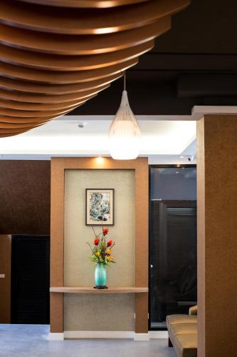 a vase of flowers sitting on a table in a room at Villa Baron SHA PLUS in Nonthaburi