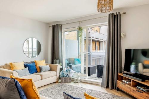 a living room with a couch and a tv at Harbourside Retreat - Spacious Balcony with Harbour Views in Poole