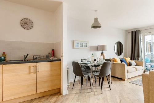 a kitchen and living room with a table and chairs at Harbourside Retreat - Spacious Balcony with Harbour Views in Poole