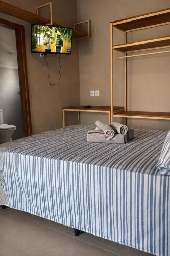a bedroom with a bed with two towels on it at Pousada Green House Paraty in Paraty