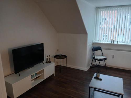 a living room with a large flat screen tv at city apartment, next to the Beach in Fredericia