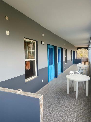 a room with a white table and blue doors at Djabraba's Triplex in Vila Nova Sintra