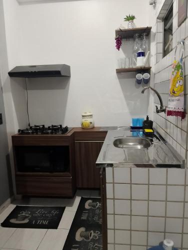 a small kitchen with a sink and a stove at Kitnet mobiliado a minutos do Parque do Povo in Campina Grande