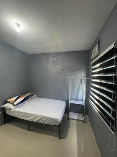 a small bedroom with a bed and a window at Evas Inn in General Santos