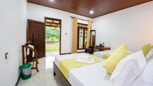 two beds in a room with a window at Tranquil Guest in Sigiriya
