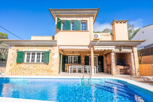 a villa with a swimming pool in front of a house at Villa Trobadors in El Arenal