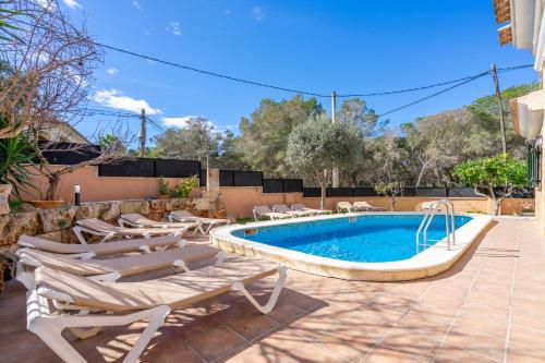 a swimming pool with chaise lounge chairs and a swimming pool at Villa Trobadors in El Arenal