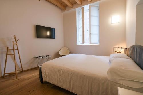 a bedroom with a bed and a tv on the wall at Locanda Alberti in Mandello del Lario