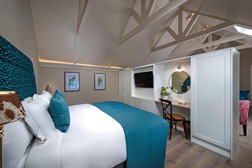 ein Schlafzimmer mit einem großen weißen Bett und einem Schreibtisch in der Unterkunft Monks Ballyvaughan in Ballyvaughan
