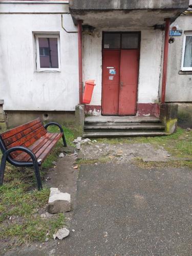 a bench in front of a house with a red door at Amy&Domy in Iscroni