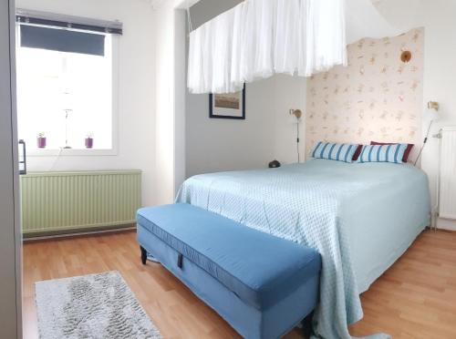 a bedroom with a blue bed and a window at Parkvillan Sunshine Living Condo in Koppom
