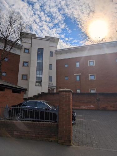 a car parked in a parking lot in front of a building at 2 Bedroom 2 Bath Apartment, sleeps 4, Town Centre in Wolverhampton