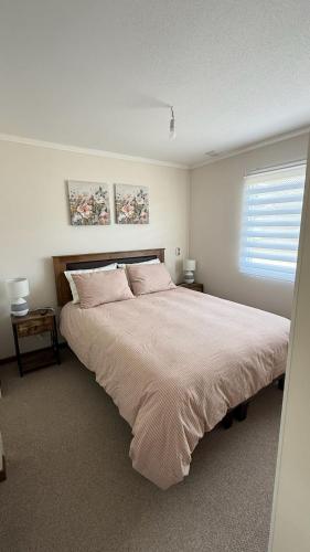 a bedroom with a large bed and a window at Pucon, casa condominio in Pucón