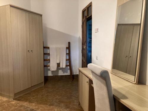 a bathroom with a vanity with a mirror and a sink at KC Bungalows in Nungwi