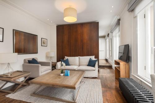 a living room with a couch and a tv at Victoria Apartments in London
