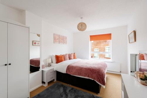 a white bedroom with a bed and a window at La Casa Bianca in Bury Saint Edmunds