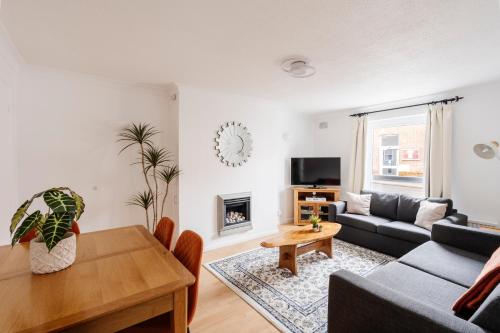 a living room with a couch and a table at La Casa Bianca in Bury Saint Edmunds