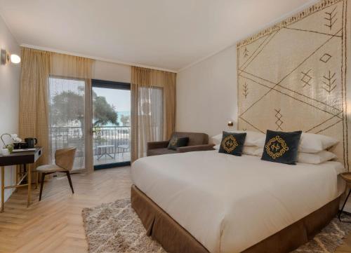 a bedroom with a large bed and a desk at The Herbert Eilat - All inclusive Plus in Eilat